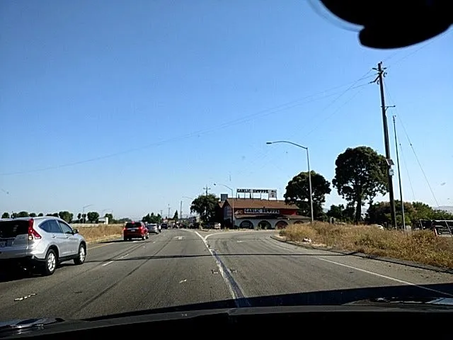 Dashcam view of a multi-lane road with a car ahead and the phone mount visible at the top right